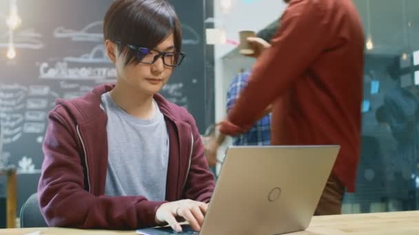 有才华的亚洲开发商坐在桌上工作的笔记本电脑 在后台繁忙的办公室与创造性的人在个人电脑上工作 概述计划在玻璃板与粘性纸 — 图库视频影像
