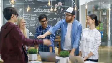 Yaratıcı geliştiricilerin çeşitli takımız başarılı ortaklık jest bina. Mutlu başarılı genç insanlar şık ve Trendy ofis ortamında giyinmiş.