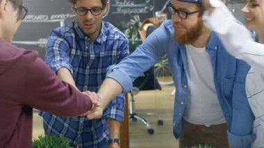 Yaratıcı geliştiricilerin çeşitli takımız başarılı ortaklık jest bina. Mutlu başarılı genç insanlar şık ve Trendy ofis ortamında giyinmiş.