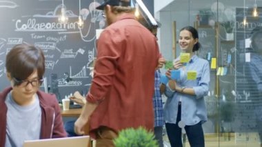 İhtimal nerede dizüstü bilgisayarlar, kişisel bilgisayarlar ve yapışkan kağıt ile anahat proje planı bir cam duvar yaratıcı gençlerin iş meşgul ofis.