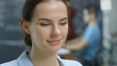 Tatlı gülmeyen güzel genç esmer. Arka planda odak yaratıcı çevre insanlar ile dışarı.