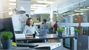 Güzel bir İspanyol işkadını çalışma gününün hızlandırılmış. O meşgul bir uluslararası ofiste farklı yerde çalışıyor takım çalışmasının yetenekli genç insanlar dizüstü bilgisayarlar, var toplantılar, tartışmalar.