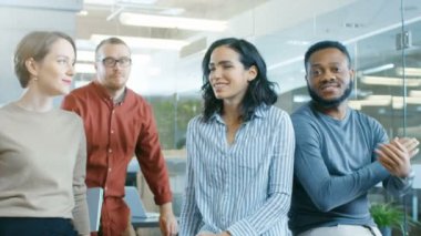 Şık Modern ortamında masada oturan yetenekli genç profesyonellerin farklı grup portre vurdu. Gerçek insanlar içtenlikle kameraya gülümseyen.