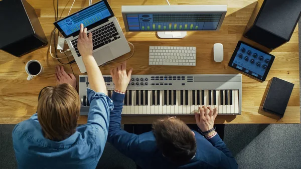 顶视图的两个音频工程师在他们阳光工作室工作 他们玩音乐键盘和实验的声音 — 图库照片