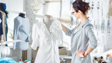 Güzel kadın moda, Tasarımcısı, terzilik manken ile çalışma. Süs detay bir forması sabitleme. Sunny, çeşitli rulo, renkli kumaş döşeme etrafında onu stüdyom.