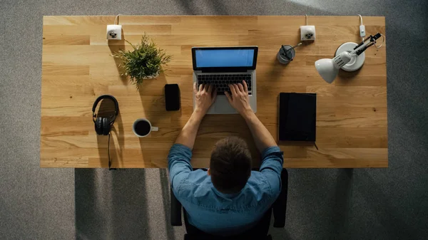 彼のテーブルに座っているデスクトップ コンピューター上で動作するソフトウェア エンジニアの平面図です 表はきちんとした スマート フォン コーヒー カップが ヘッドフォンが横たわる — ストック写真