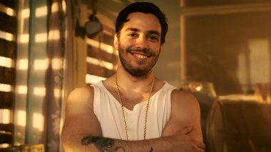Şık İspanyol adam silah haçlar ve Smirks / gülümsüyor kameraya. Boarded yukarıya pencere eşiği ile arka plan terk binada.