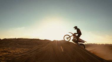 Profesyonel motokros motosiklet binici Dune atlama ve Off-Road parça aşağı daha fazla. Güneş batıyor görürken ocağı terk vurdu.