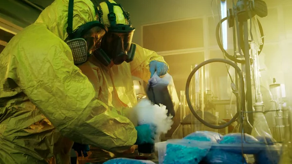 在地下毒品实验室两个秘密化学家混合化学品同时烹饪的麻醉品 他们使用的滤毒罐和烧杯 有毒化合物创建烟 他们在废弃的大楼里工作 — 图库照片