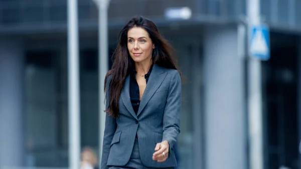 Business Woman in the Tailored Suit Walking on the Busy Big City Street in the Business District. Confident Woman on Her Way to do Big Business.