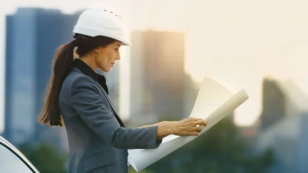 Female Real Estate Developer Looks Project Drafts While Standing Big — Stock Photo, Image