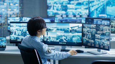 Şüpheli faaliyetleri için güvenlik denetimi Oda görevlisi monitörler çoklu ekranlar bir kupa içki içer. Monitörler ve muhafızlar bağlantı noktası ulusal öneme sahip çevrilidir.