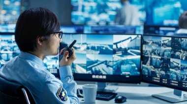 Güvenlik kontrol odasında memur monitör birden çok şüpheli, hareketleri, o raporlar herhangi bir izinsiz etkinlikler O'nun walkie-talkie ekranlar. Monitörler ve muhafızlar bağlantı noktası ulusal öneme sahip çevrilidir.