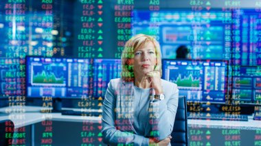 Borsa kadın üst yöneticisi öngörülen Ticker numaraları ve grafikler arar. Odasına arkasında tam ekranlar ve istatistik.