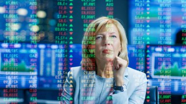 Borsa kadın üst yöneticisi öngörülen Ticker numaraları ve grafikler arar. Odasına arkasında tam ekranlar ve istatistik.
