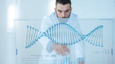 Fütüristik laboratuvarda erkek bilim adamı insan Dna dizisi ile onun şeffaf bilgisayar ekranında çalışır.