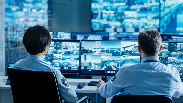 Sicherheitskontrollraum Überwachen Zwei Beamte Mehrere Bildschirme Auf Verdächtige Aktivitäten Und — Stockfoto
