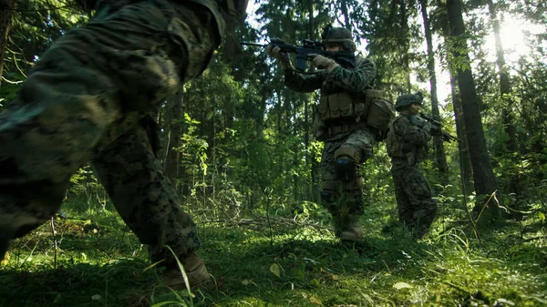 全副武装的士兵小队在一个侦察军事任务 瞄准步枪伪装 他们正在通过密森林进入阵型 低角度视频 — 图库照片