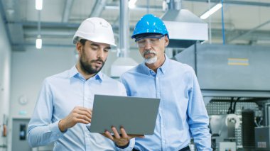Onlar yürümek ile Modern fabrika proje Laptop tutar ve ürün ayrıntılarla anlatılır şef mühendis Başkanı iken.