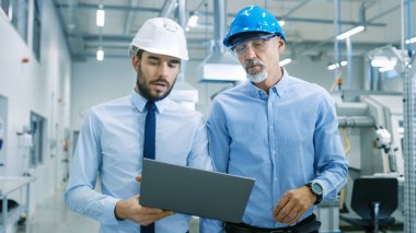 Onlar yürümek ile Modern fabrika proje Laptop tutar ve ürün ayrıntılarla anlatılır şef mühendis Başkanı iken.