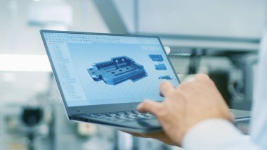 Cad bileşen modeli ile dizüstü bilgisayar ekranında tutan mühendisi Close-up. Arka plan Modern fabrika ekipmanları.