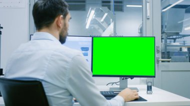 Mühendis / teknisyen çalışma ile iki göstermek, bir kişisel bilgisayarda Mockup için yeşil ekran Chroma anahtar şablon harika biri. Ofis pencere bileşenleri üretim fabrikası dışında görülür.