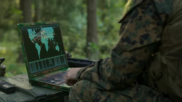 军事行动中 使用军用级笔记本电脑的士兵使用军用工业复杂硬件完成国际任务 在背景伪装的帐篷在森林 — 图库照片