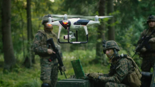 In the Military Staging Base Army Engineer and Soldiers Fly Military Grade Industrial Drone for their Reconnaisance/ Surveillance Mission/ Operation. Theater of Operation is in Forest Area.