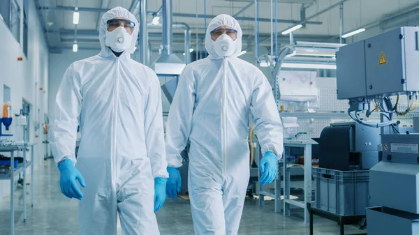 两名工程师 科学家在危险品无菌西装步行通过技术先进的工厂 实验室 Cnc 机械清洁高科技环境 — 图库照片