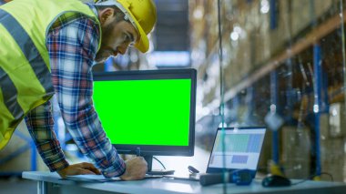 Erkek Müfettiş onun kişisel bilgisayar ile yeşil ekran şablonu büyük elektronik tablolara kadar Mockup için doldurur. Palet raflar satır içeren büyük bir depo içinde.