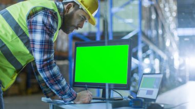 Erkek Müfettiş onun kişisel bilgisayar ile yeşil ekran şablonu büyük elektronik tablolara kadar Mockup için doldurur. Palet raflar satır içeren büyük bir depo içinde.