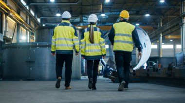 Atış üç mühendisleri ağır sanayi ile fabrika imalatı yürüyen takip. Yapım aşamasında, çeşitli metal işleri, boru hattı kaynak arka planda / varil bileşenleri.