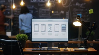 Ofis masasında, arka plan insanlar iş yaratıcı ofiste Blackboard duvara monitörde gösterilen mobil uygulama tasarımı ile kişisel bilgisayar standları.