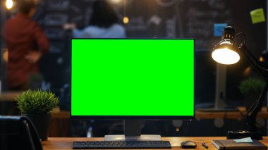 Ofis masasında, arka plan insanlar iş yaratıcı ofiste Blackboard duvara Mock-up yeşil ekran monitör ile kişisel bilgisayar standları.
