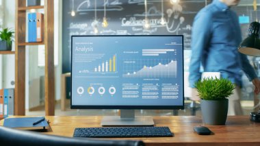 Ofis masasında, gündüz ofis ortamında çalışan adam arka plan monitörde gösterilen mobil uygulama tasarımı ile kişisel bilgisayar standları.