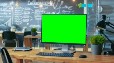 Kişisel bilgisayar Mock-up yeşil ekran monitör ofis masasında adam arka plan standları ile yaratıcı ofiste gündüz çalışıyor..