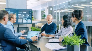 Üst düzey yönetici şirketin vizyon ve potansiyel onun çalışanları için açıklar. Onlar toplantı odasında büyük masada oturuyorlar. Duvar TV ekranında kurumsal büyüme gösterir.