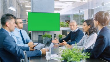 Farklı grup başarılı iş adamları yeşil ekran Chroma anahtar Tv duvar ile konferans odasında. Onlar bir şirketin büyüme, paylaşım grafikler ve istatistik iş.