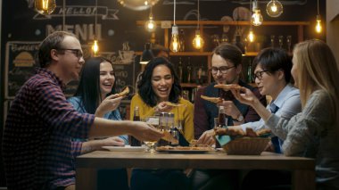 Bar / Restoran grubu farklı gençlerin yemek Pizza pasta grafiğin dilimlerini. Onlar konuşmak, espri ve şık bu işyerinde iyi eğlenceler.