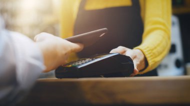Cafe işçi parasını ödeyen bir müşteri tarafından kredi kartı sistemine temassız cep telefonu satış paket servisi olan restoran kahve.