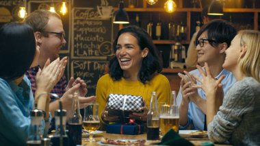 Bar / Restoran iyi arkadaş hediye vermek için güzel bir İspanyol kadın, onun mutlu yıllar dileğiyle. Herkes mutlu olduğunu.