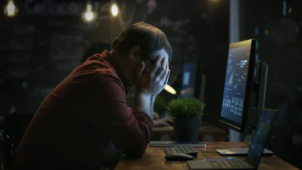 Stressed Financier Hits the Table with His Fist in Frustration and Covers His Face in Hands. He\'s Working on a Personal Computer with Statistics Showing on the Screen.
