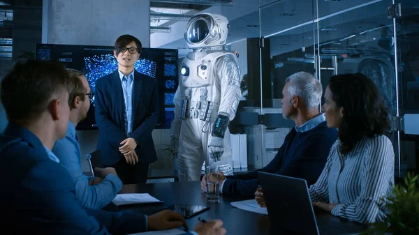 In the Conference Room of the Center of Technology Chief Engineer Presents Next Generation Space Suit to a Board of Directors. Completely Original Design with Integrated AI and Neural Network Systems.