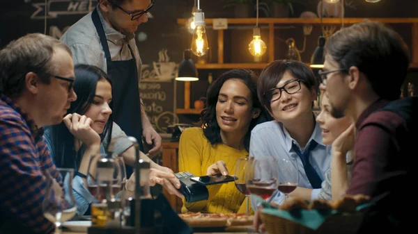 Bardaki garson tutar kredi kartı ödeme makine ve güzel kadın öder emrine temassız cep telefonu ödemeler sistemi ile için. O sevgili arkadaşlar çevrili ve çok iyi vakit vardır.