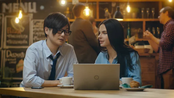 男前な男性と カフェに座っている美しい白人女性のラップトップ コンピューター上で動作します 背景その他顧客のスタイリッシュな環境で — ストック写真