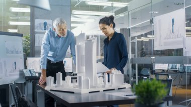 Mimari büro iki mühendisleri bir şehir ilçe bir Model üzerinde çalışır. Kentsel planlamacılar iş fonksiyonel yapı modeli.