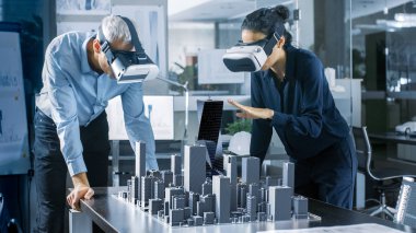 Erkek ve dişi Mimarlar giyen gerçeklik kulaklık iş 3d şehir modeli ile artar. High Tech Office profesyonel insanlar sanal gerçeklik modelleme yazılımı kullanın.