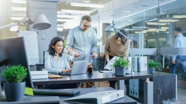 Uluslararası Ofis çeşitli yerlerde meşgul takım genç iş kadınları ve iş adamları iş dizüstü bilgisayarlar, var toplantılar, tartışmalar ve bir beyaz tahta üzerinde planları çizmek.