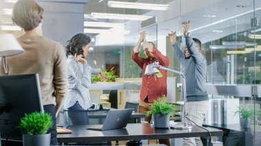 Çeşitli grup genç kadınlar ve erkekler dans ve Modern ofiste iyi eğlenceler. Siyah genç adam güzel İspanyol kadın döner.