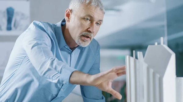 Male Senior Engineer and Female Architectural Designer Work on a Building Model Design for the Urban Planning Project.